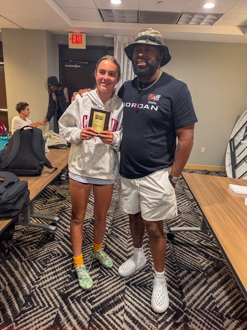 Kennedy Ford holding her award plaque with a TOUR coach